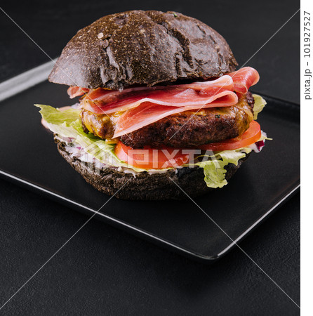 Modern black burger with prosciutto ham 101927527