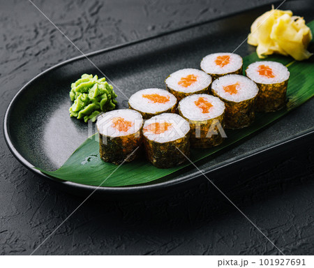 Row of fresh maki sushi rolls on black plate Row of fresh maki sushi rolls on black plate 101927691
