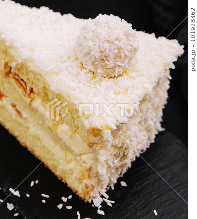 Coconut layered, raffaello cake on black tray 101928362