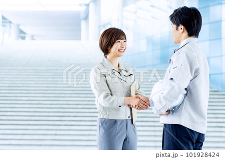 作業着で握手をする男女 作業着で握手をする男女 101928424