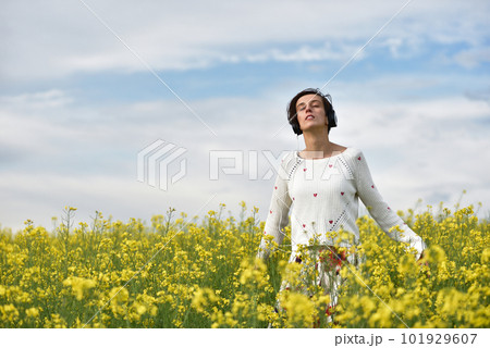 Caucasian girl listening to music with headphone in the outdoors 101929607