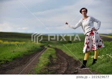 Sexy young woman in dress hitchhiking near a countryside road 101929677
