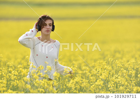 Beautiful Caucasian girl listening to music with headphone in the outdoors 101929711