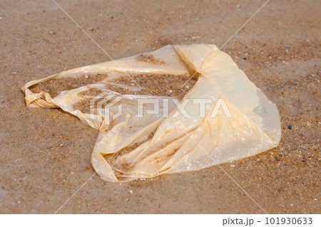 Plastic bag pollution on the beach 101930633