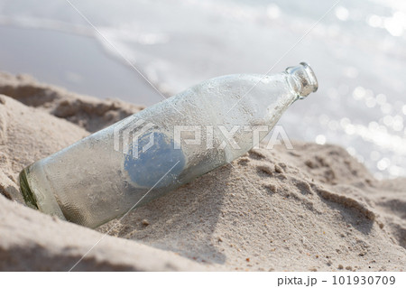 Glass bottle on the beach 101930709
