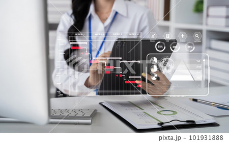 Business woman hand Project manager working and update tasks and Gantt chart scheduling virtual diagram.with tablet and laptop in office. Business woman hand Project manager working and update tasks and Gantt chart scheduling virtual diagram.with tablet and laptop in office. 101931888