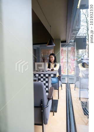 Calm concentrated freelancer using her laptop in a cafe 101932330