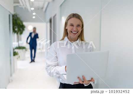 Cheerful businesswoman with the laptop in her hands looking ahead Cheerful businesswoman with the laptop in her hands looking ahead 101932452