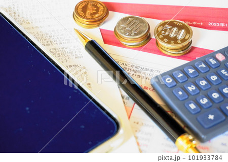 資料の上に並べられた各種硬貨と電卓、ペン、スマートフォン 資料の上に並べられた各種硬貨と電卓、ペン、スマートフォン 101933784