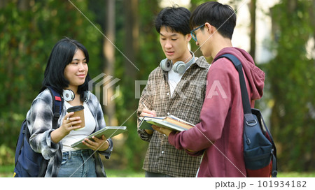 Group of students are talking to each other after classes while walking outdoors in university. Education and youth lifestyle concept 101934182