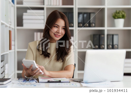 Asian Business Woman or Accountant do math and analyze with calculator and paperwork on desk, account, audit and saving, research, finance concept Asian Business Woman or Accountant do math and analyze with calculator and paperwork on desk, account, audit and saving, research, finance concept 101934411