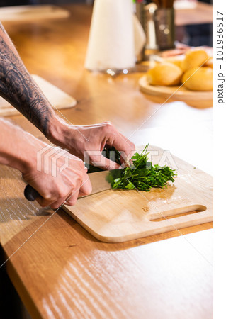 Premium Photo  Chef chopping parsley with knife on a wooden board close up