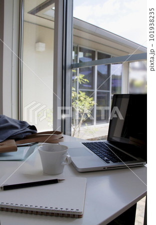 女性のデスク　戸建て住宅　ノートパソコンと書類　カバンとスーツ 101938235
