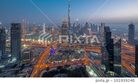 Aerial view of tallest towers in Dubai Downtown skyline and highway day to night timelapse. Aerial view of tallest towers in Dubai Downtown skyline and highway day to night timelapse. 101939240