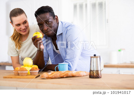 Loving couple enjoying while spending time together in home kitchen Loving couple enjoying while spending time together in home kitchen 101941017