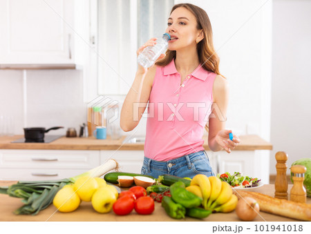 Attractive woman drinking water in the kitchen before breakfast Attractive woman drinking water in the kitchen before breakfast 101941018