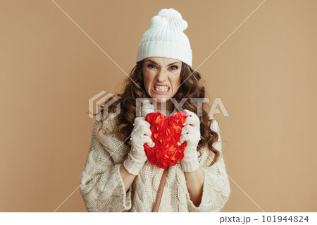 angry stylish woman isolated on beige background with red heart 101944824