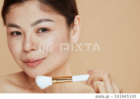 Portrait of modern woman with makeup brush 101945145