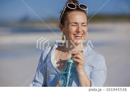 smiling elegant woman with drink at beach 101945536