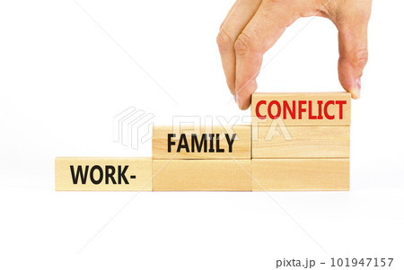Work-family conflict symbol. Concept words Work-family conflict on wooden block on a beautiful white table white background. Businessman hand. Business work-family conflict concept. Copy space. Work-family conflict symbol. Concept words Work-family conflict on wooden block on a beautiful white table white background. Businessman hand. Business work-family conflict concept. Copy space. 101947157