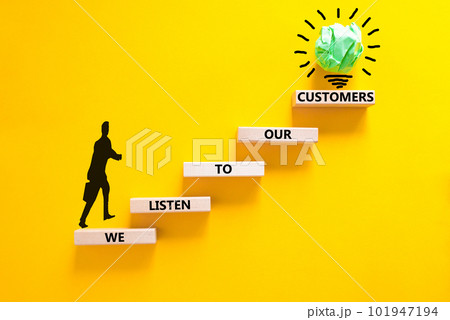 We listen to our customers symbol. Concept words We listen to our customers on wooden block. Beautiful yellow background. Businessman icon. Business we listen to our customers concept. Copy space. 101947194
