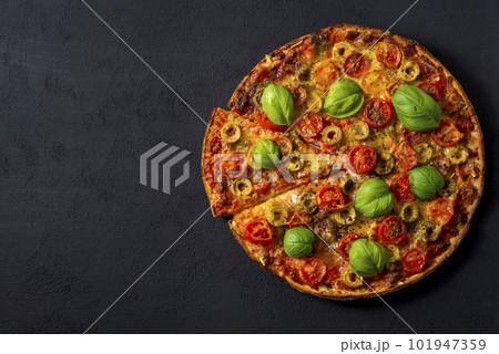 Pizza Margherita with basil tomato and mozzarella, top view on a black background . 101947359