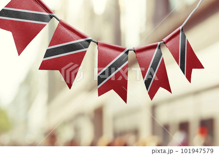 A garland of Trinidad and Tobago national flags on an abstract blurred background 101947579