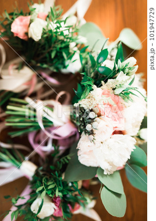 Beautiful toned picture with wedding rings against the background of a bouquet of flowers 101947729