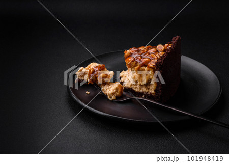 Delicious fresh cheesecake cake or snickers with cream and nuts Delicious fresh cheesecake cake or snickers with cream and nuts 101948419