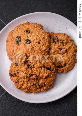 Delicious baked oatmeal raisin cookies on a dark concrete background 101948433