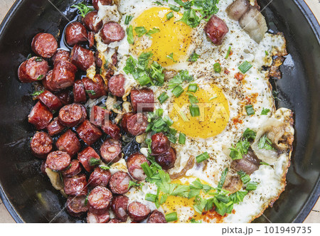 scrambled eggs with sausage and greens in a frying pan close-up scrambled eggs with sausage and greens in a frying pan close-up 101949735