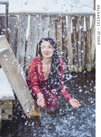 Attractive woman in red dress bathes in the ice-hole in winter Attractive woman in red dress bathes in the ice-hole in winter 101949766