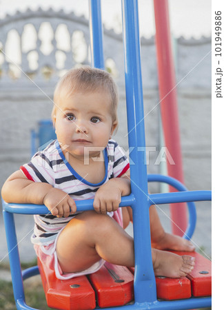 Blonde baby on a swing at sunset Blonde baby on a swing at sunset 101949886