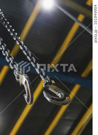metal hook hanging on a chain in a factory focus on the hook 101949904