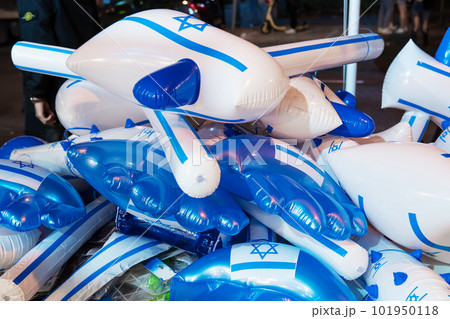 Toys as an inflatable hammers and a clubs with images of national symbols of Israel are sold on the street at night 101950118