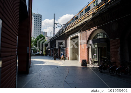 東京神田万世橋・高架線路を通過する鉄道と古いレンガ造りの壁のある街並み 101953401