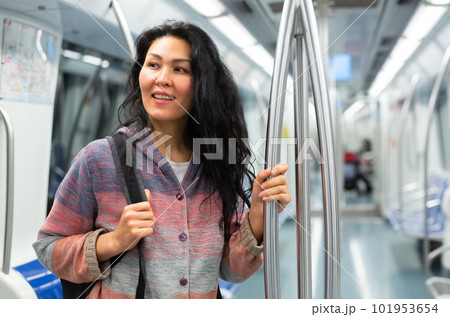 Young woman passenger sitting in subway car 101953654