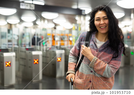 Asian woman passing through ticket gates in public transportation station Asian woman passing through ticket gates in public transportation station 101953710