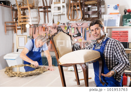 Male carpenter working on making vintage chair in workshop Male carpenter working on making vintage chair in workshop 101953763