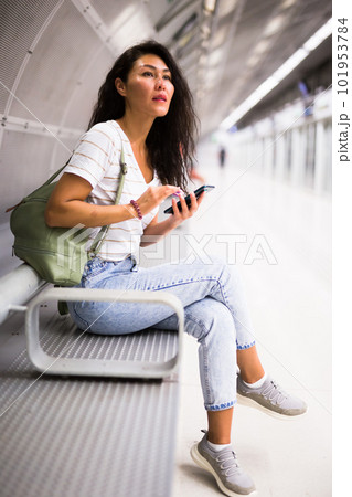 Woman using smartphone while waiting for train in metro station 101953784