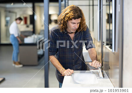 Man customer choosing faucet or spigot combination set for water supply 101953901