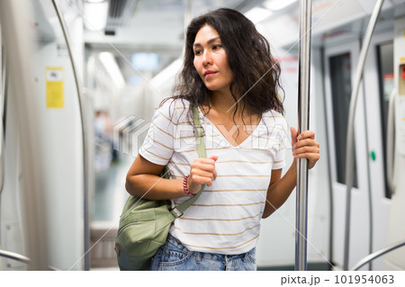 Woman standing in subway train Woman standing in subway train 101954063