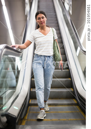 Woman going through escalator 101954081