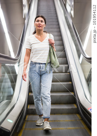 Woman going down to subway station on escalator 101954112