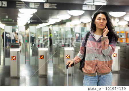 Asian woman passing through ticket gates in public transportation station Asian woman passing through ticket gates in public transportation station 101954139