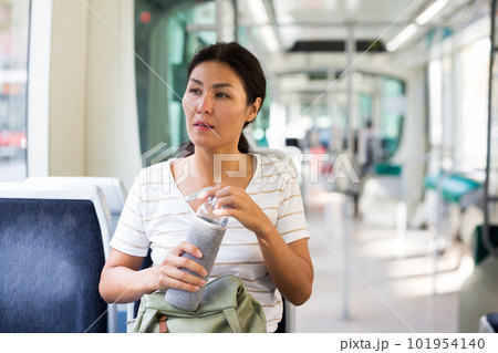 Woman with bottle in tram Woman with bottle in tram 101954140