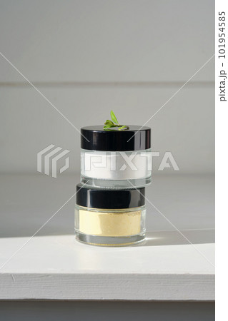 Two closed jars of enzime face scrub. 101954585