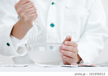 粉砕指示と薬剤師。乳棒に薬を入れて混合している手元 101956012