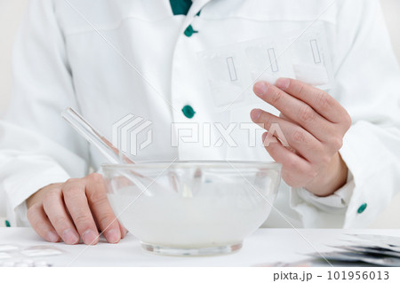 粉砕指示と薬剤師。乳棒に薬を入れて混合している手元 101956013
