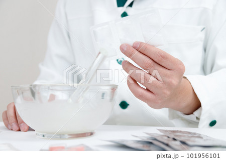 粉砕指示と薬剤師。乳棒に薬を入れて混合している手元 粉砕指示と薬剤師。乳棒に薬を入れて混合している手元 101956101